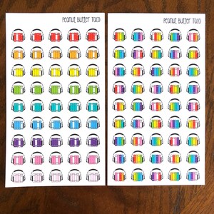 May include: Two sheets of stickers with a rainbow color scheme. Each sticker features a stack of books with headphones on top. The text "Peanut Butter Taco" is printed at the top of each sheet.