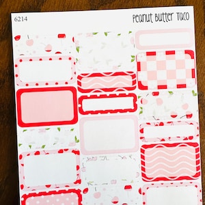 May include: A sheet of 12 pink and red patterned planner stickers with the text "Peanut Butter Taco" at the top. The stickers are rectangular and have different patterns, including polka dots, cherries, and gingham.
