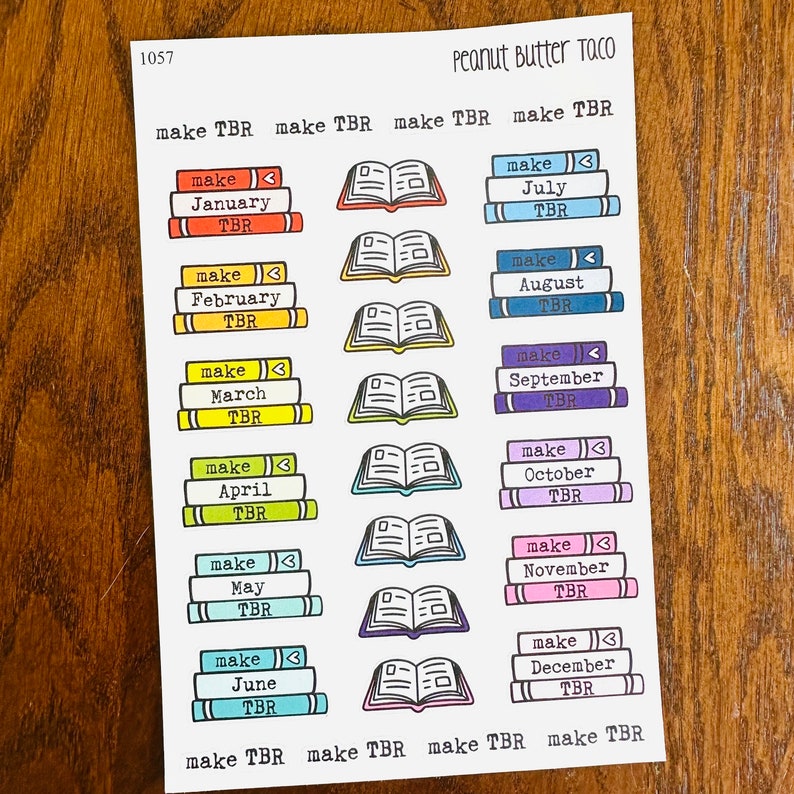 May include: A sheet of colorful stickers with illustrations of stacks of books and open books. The stickers are labeled with the months of the year and the text "make TBR".