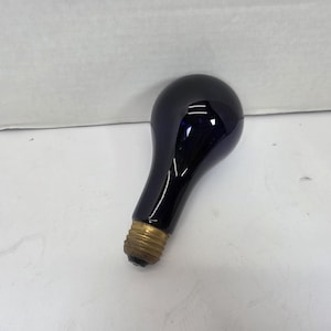 May include: A dark blue light bulb with a brass base. The bulb has a rounded top and a long, slender neck. The bulb is resting on a white surface.