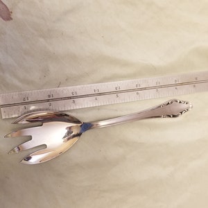 Può includere: Una forchetta da insalata in argento con un manico decorativo. La forchetta è lunga 17,8 cm e ha tre rebbi.