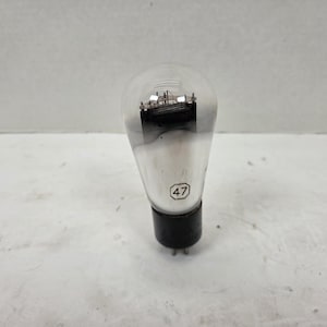 May include: A vintage vacuum tube with a clear glass bulb and a black base. The tube has internal components visible through the glass and the number "47" is printed on the side. The tube is designed for electronic devices.