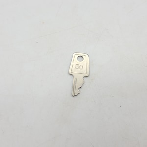 May include: A silver key with a square head and the number "50" printed on it.