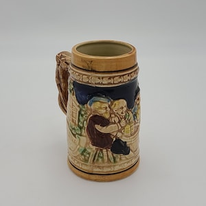 Vintage German beer stein people gathered at table