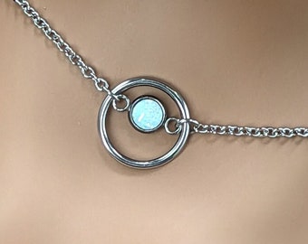 May include: A silver chain necklace with a circle pendant featuring a white opal stone.