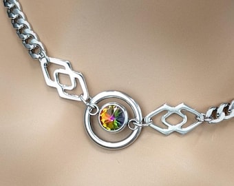 May include: A silver chain necklace with a round pendant featuring a multi-colored iridescent gemstone.