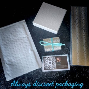 Puede incluir: Un sobre acolchado blanco, una caja de regalo blanca, una peque&ntilde;a caja de regalo plateada con una cinta turquesa, una caja de regalo dorada y una tarjeta de visita con un c&oacute;digo QR y el texto "Brandi Terrell" se muestran sobre una superficie texturizada negra. El texto "Siempre embalaje discreto y caja de regalo" est&aacute; escrito en azul sobre la superficie.