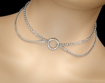 May include: A silver choker necklace with two chains and a circular pendant.