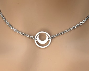 May include: A silver chain necklace with a circular pendant featuring a crescent moon cutout.