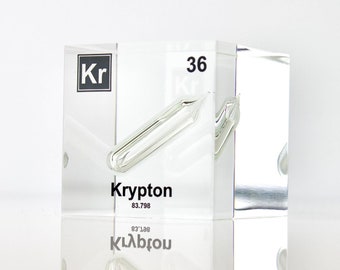 May include: A clear acrylic cube displaying the element Krypton (Kr). The cube shows the atomic number 36 and atomic weight 83.798. The word Krypton is also written on the cube.