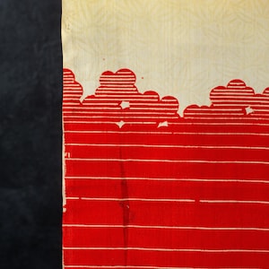 May include: Textile with a two-tone design. The top portion is a light beige with a subtle leaf pattern. The bottom section is bright red with horizontal white stripes and cloud-like shapes at the top. A black border is on the left.