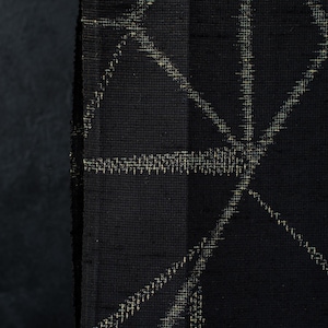 May include: A black fabric featuring a geometric pattern composed of thin, light-colored lines that intersect to form various angular shapes. The material has a visible woven texture with a matte finish, and the lines appear slightly blurred.