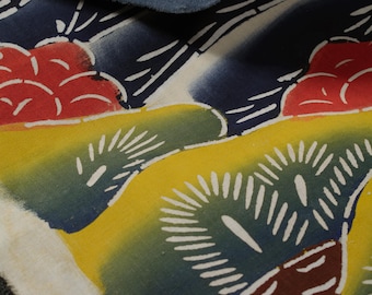 May include: A close-up of a fabric with a Japanese-inspired design. The fabric features a white background with blue, red, yellow, and green floral patterns. The fabric is textured and has a slightly faded appearance.