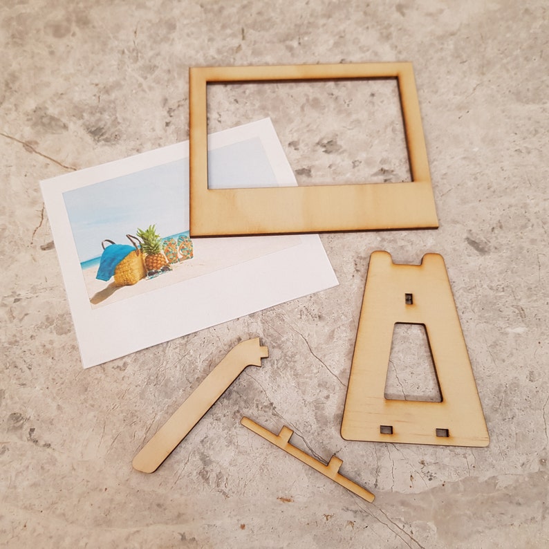 Peut inclure: Un cadre photo en bois avec un support, un petit chevalet en bois et une pi&egrave;ce de support en bois. Le cadre est con&ccedil;u pour contenir une photo ou une autre &oelig;uvre d'art.