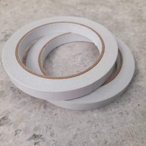 May include: Two rolls of white double-sided adhesive tape.