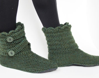 Può includere: Un paio di stivaletti da camera in crochet verde con chiusura a bottone. Gli stivaletti hanno un bordo a festoni e sono realizzati con un filato morbido e testurizzato.