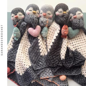 Può includere: Modello all'uncinetto per una coperta a forma di pinguino. La coperta è bianca, grigia e nera, con una testa di pinguino e piccoli accenti di pesce e cuore all'uncinetto. Il testo "CROCHET PATTERN" e "SARAHDEECROCHET" sono visibili.