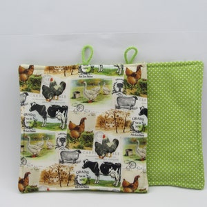 Pode incluir: Um par de pegadores de panela verdes e brancos com um tema de fazenda. Um lado apresenta um fundo branco com um padrão repetitivo de animais de fazenda, incluindo galinhas, vacas, ovelhas e gansos. O outro lado é verde sólido com bolinhas brancas.