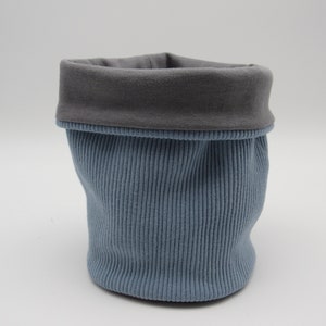 May include: A blue and grey fabric storage basket with a ribbed texture.