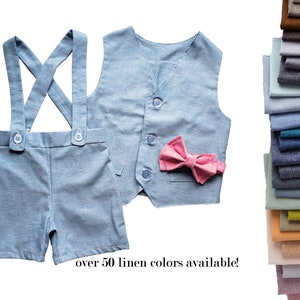 May include: A light blue linen outfit for a child, consisting of shorts with suspenders and a matching vest. The vest has a pink bow tie. The text "over 50 linen colors available!" is printed below the outfit.