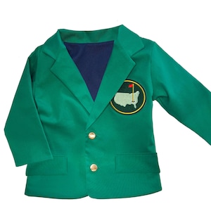 May include: A green blazer with a navy blue lining and gold buttons. The blazer features a circular patch with a golf course map and a red flag. The jacket is designed for a child.