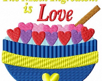 May include: A blue bowl filled with pink, purple, and red hearts. A wooden spoon sits on top of the bowl. The text "The Main Ingredient is Love" is written above the bowl.