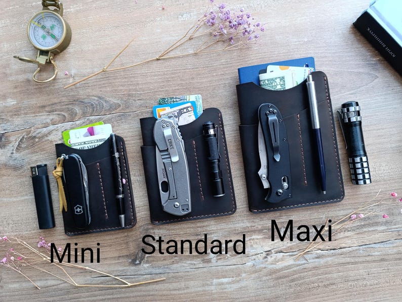 May include: Three leather wallet styles, labeled "Mini", "Standard", and "Maxi", with different sized pockets for carrying cash, cards, and small tools. Each wallet has a brown leather exterior with contrasting stitching.