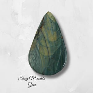 May include: A teardrop-shaped gemstone with a polished surface. The stone features a blend of green and gold hues with natural veining patterns. The text "Stony Mountain Gems" is written in cursive at the bottom.