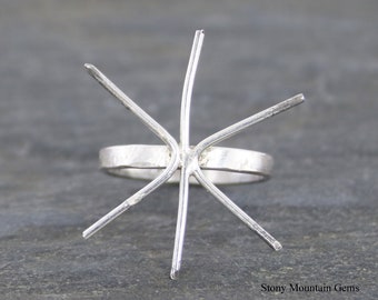 Puede incluir: Engaste de anillo de plata con seis garras, listo para ser engastado con una piedra preciosa. La banda del anillo es texturizada.