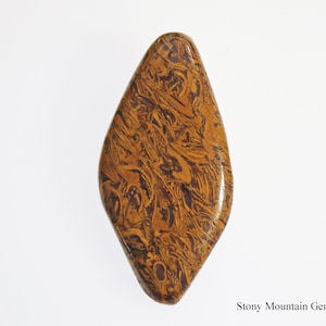 May include: A polished, elongated gemstone with a unique pattern of swirling brown and tan colors. The stone has a smooth, glossy surface and a teardrop shape. The gemstone is a natural product.