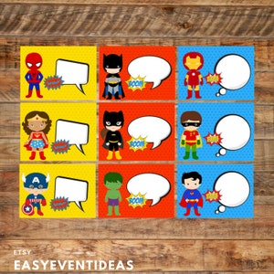 May include: Nine colorful superhero-themed cards with comic book style illustrations. Each card features a different superhero, a speech bubble, and a "BOOM" or "WOW" sound effect. The cards are set against a wooden background.