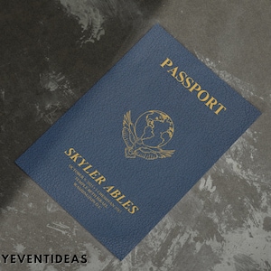 Puede incluir: Un pasaporte azul con el texto "PASSPORT" en letras doradas. El pasaporte tiene un diseño de globo dorado con alas y el nombre "SKYLER ABLES" impreso debajo. El texto "OCTOBER 9, 2003, CHEYENNE, WY", "TEMPLE, TX BIRTHPLACE", y "WASHINGTON, DC" está impreso debajo del nombre.
