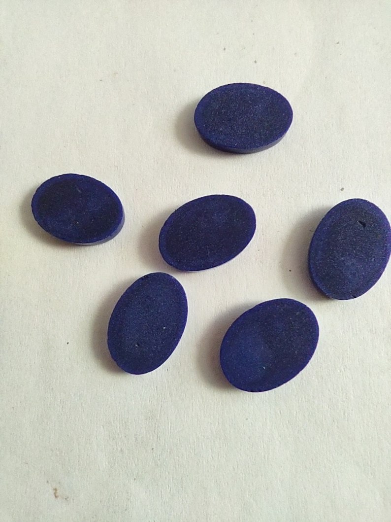May include: Six oval-shaped, dark blue gemstones. The gemstones are smooth and polished.