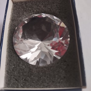 May include: A large, clear crystal diamond paperweight in a blue box with gray foam padding.