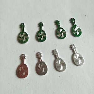 May include: Nine metal guitar-shaped charms with a swirling design. The charms are in three colors: green, silver, and a reddish-brown.