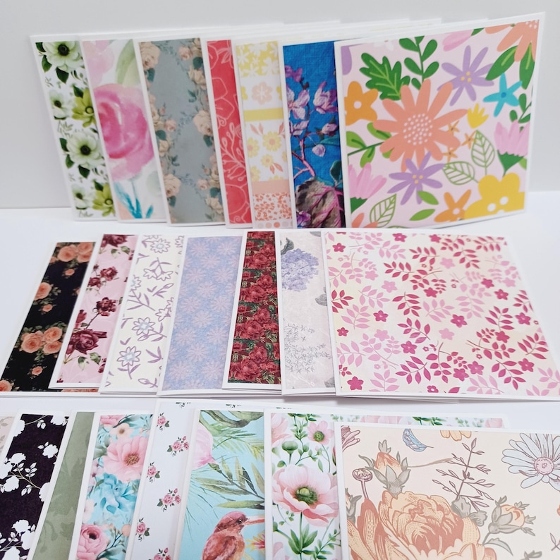 May include: A collection of rectangular paper cards featuring various floral and botanical patterns in diverse color palettes including pink, blue, yellow, and green. The designs include illustrations of flowers, leaves, and birds, arranged in multiple rows and overlapping layers.