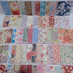 May include: A large collection of rectangular paper cards featuring a diverse array of floral and botanical patterns in various colors including red, blue, pink, yellow, and green, arranged in overlapping rows on a plain white surface.