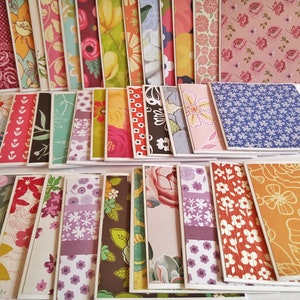 May include: A collection of rectangular greeting cards arranged in rows, each featuring a unique decorative pattern. The designs include various floral motifs, geometric shapes, and botanical illustrations in a vibrant palette of pink, yellow, blue, green, and orange.