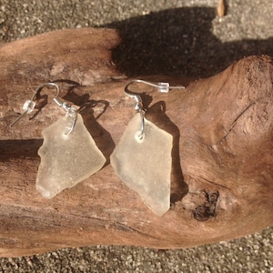 May include: A pair of earrings made from clear sea glass with silver hooks.