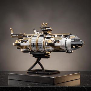 May include: A detailed model of a futuristic spaceship featuring a white, black, and gold color scheme. The vessel has a cylindrical body with grid-like patterns, multiple thrusters, and a command bridge. It is mounted on a black display stand.
