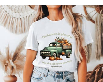 May include: White t-shirt with a green vintage truck carrying pumpkins and fall foliage. The text reads "The harvest is plentiful, but the laborers are few. Matthew 9:37"
