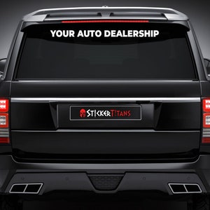 May include: A black SUV with a white decal on the back window that says "YOUR AUTO DEALERSHIP". The decal is above a smaller red decal with a Spartan helmet and the text "STICKERTITANS".