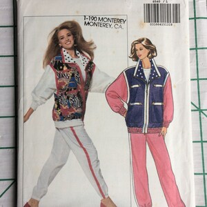 May include: A vintage sewing pattern for a women's tracksuit. The pattern is from Butterick and is size L-XL. The pattern features a white tracksuit with red stripes and a blue and pink tracksuit with white stripes.