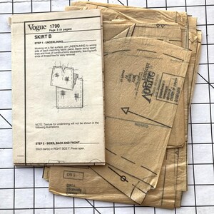May include: A vintage Vogue sewing pattern for a skirt, pattern number 1790, with instructions for underlining and stitching darts. The pattern is printed on brown paper and includes multiple pieces.
