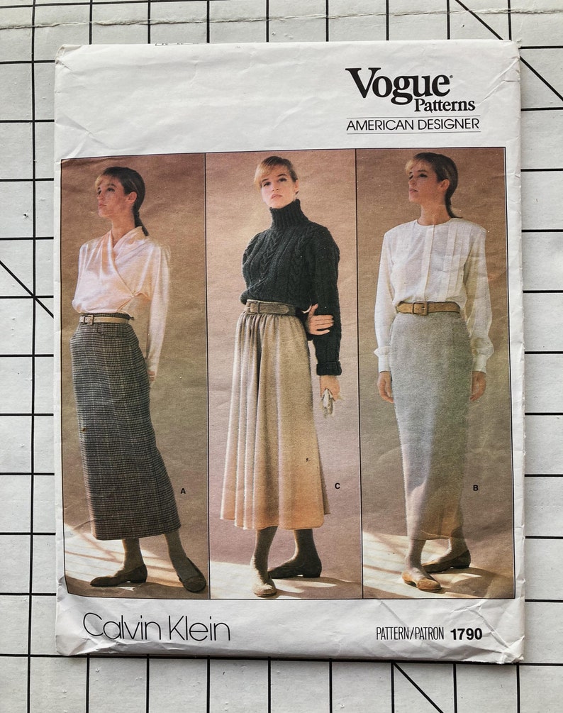 May include: Vogue Patterns American Designer sewing pattern for a skirt by Calvin Klein. The pattern number is 1790. The pattern shows three different styles of skirts: a plaid skirt, a pleated skirt, and a straight skirt.