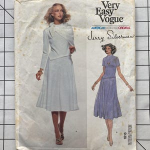 May include: Vintage Very Easy Vogue sewing pattern featuring two women's fashion designs. The cover shows a woman in a light gray skirt suit and another in a lavender dress. The pattern is by Jerry Silverman, American Designer Original.