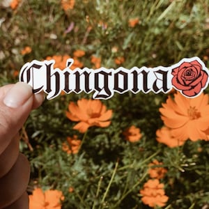 May include: A white sticker with the word "Chingona" in black gothic lettering and a red rose illustration.
