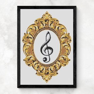 May include: A framed artwork featuring a black treble clef within an oval, set against a white background. The oval is framed by an ornate, gold-colored baroque-style border, all encased in a black frame.