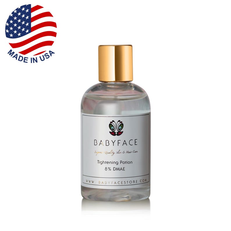 Puede incluir: Una botella de vidrio transparente con una tapa dorada y una etiqueta que dice "BABYFACE" y "Tightening Potion 8% DMAE". La botella est&aacute; sobre una superficie blanca.