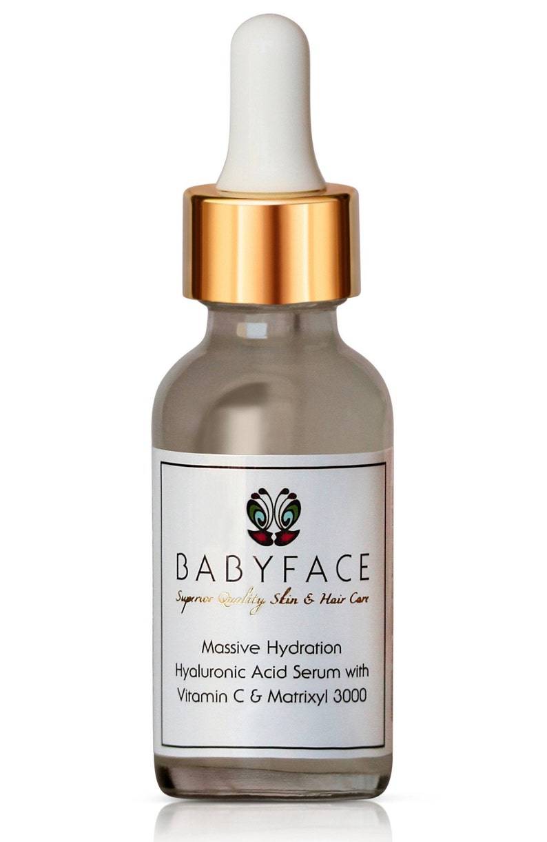 May include: A clear glass bottle with a gold lid and dropper. The bottle contains a serum for skin and hair care. The label reads "BABYFACE Superior Quality Skin & Hair Care Massive Hydration Hyaluronic Acid Serum with Vitamin C & Matrixyl 3000".